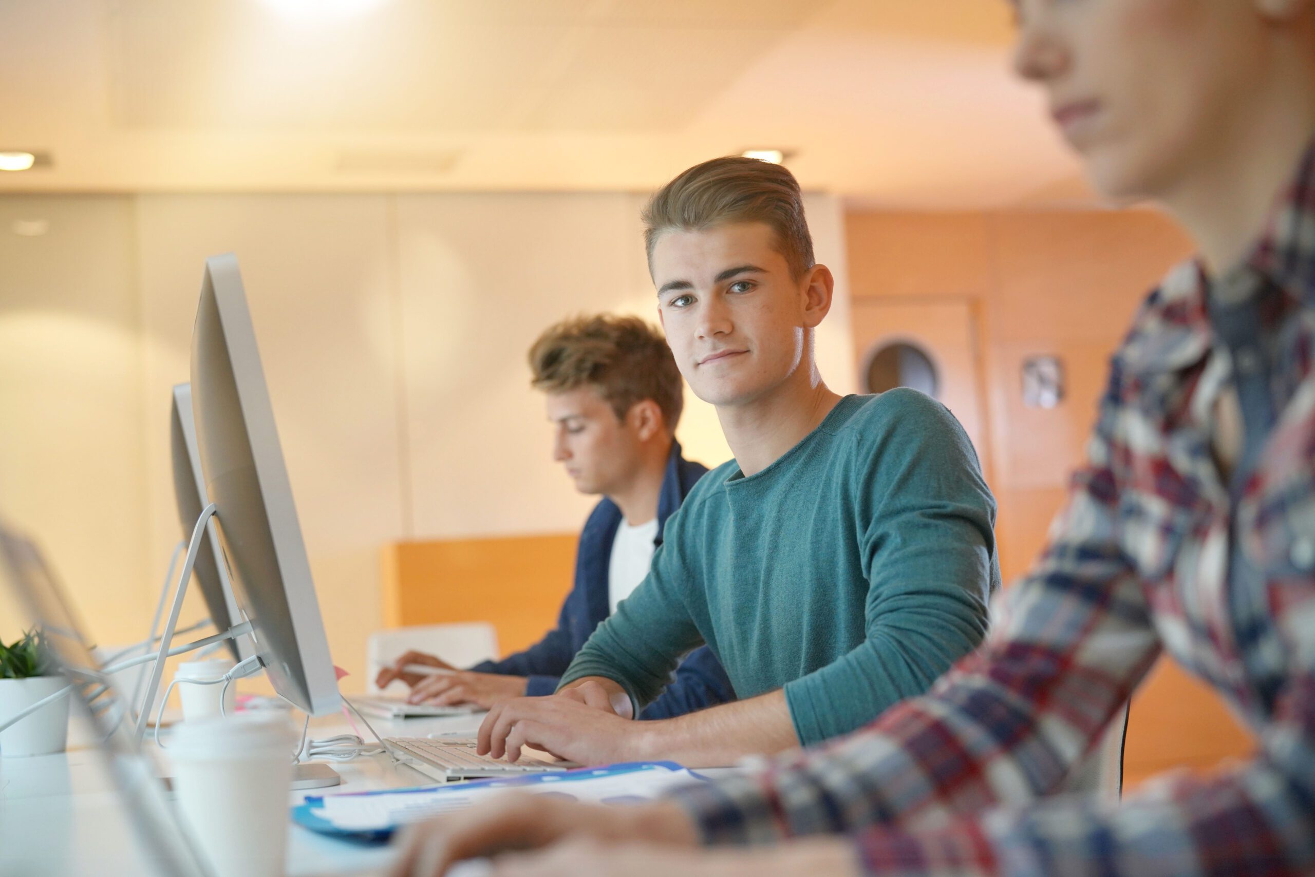 Students at desks learning on computers - AIM Qualifications