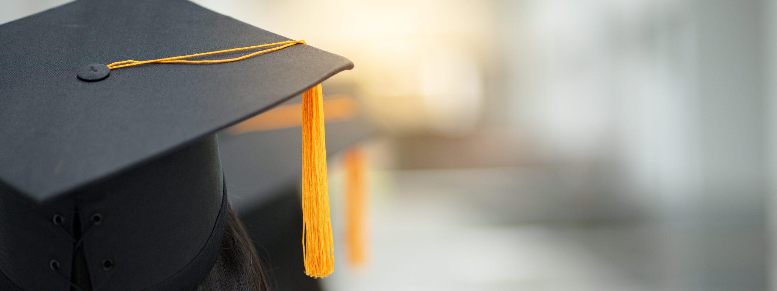 Young happy Asian woman university graduate in graduation gown and cap in the college campus. Education stock photo