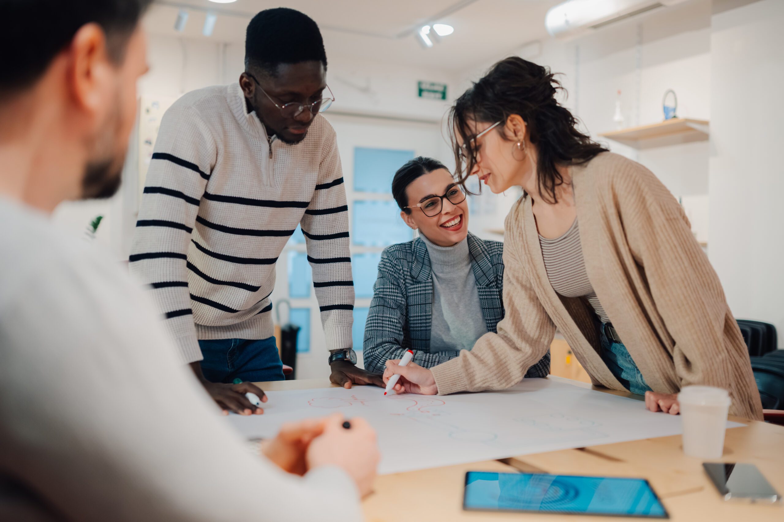 Creative business team brainstorming and planning on a large paper sheet