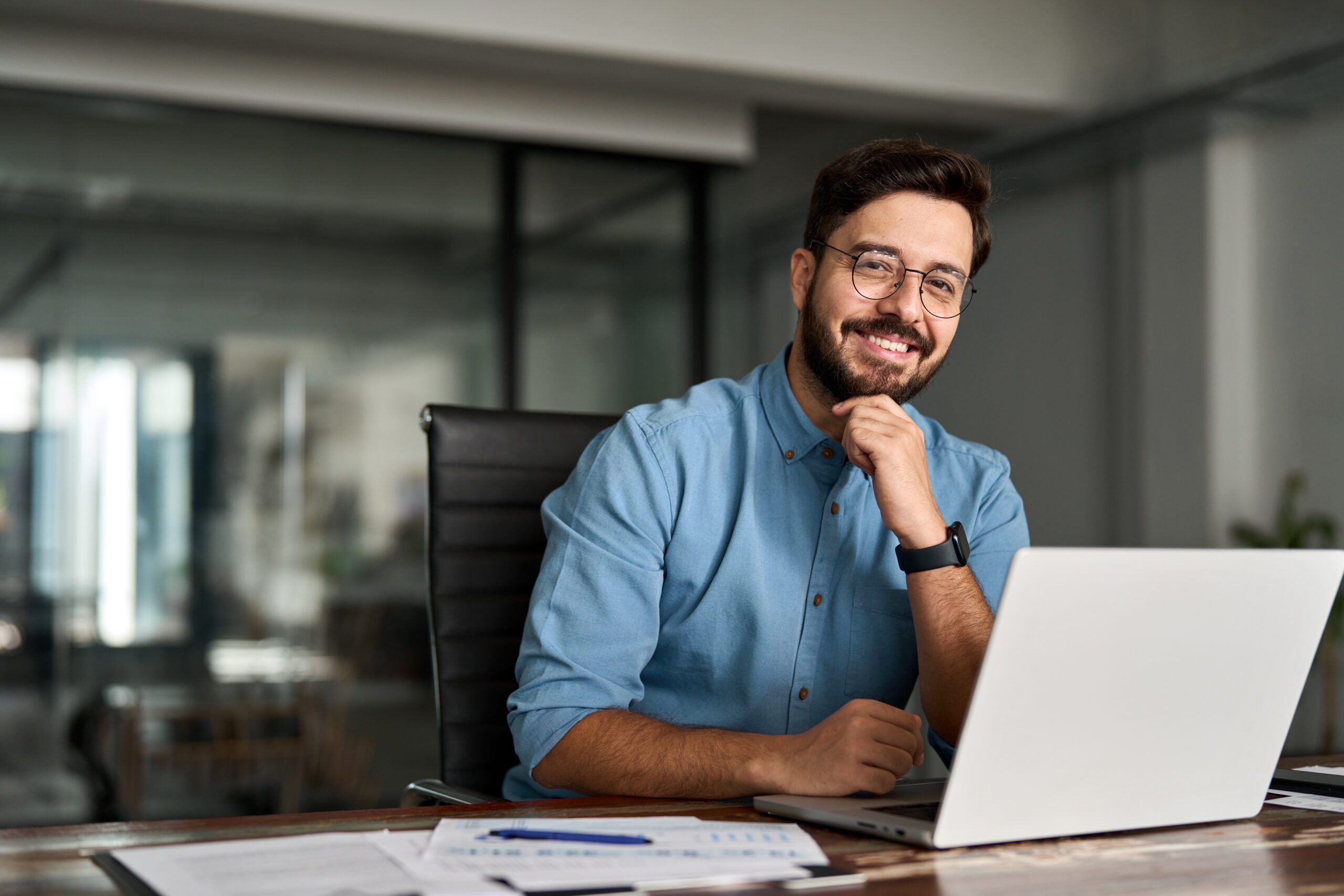 Portrait of happy professional business man looking at camera working in office.