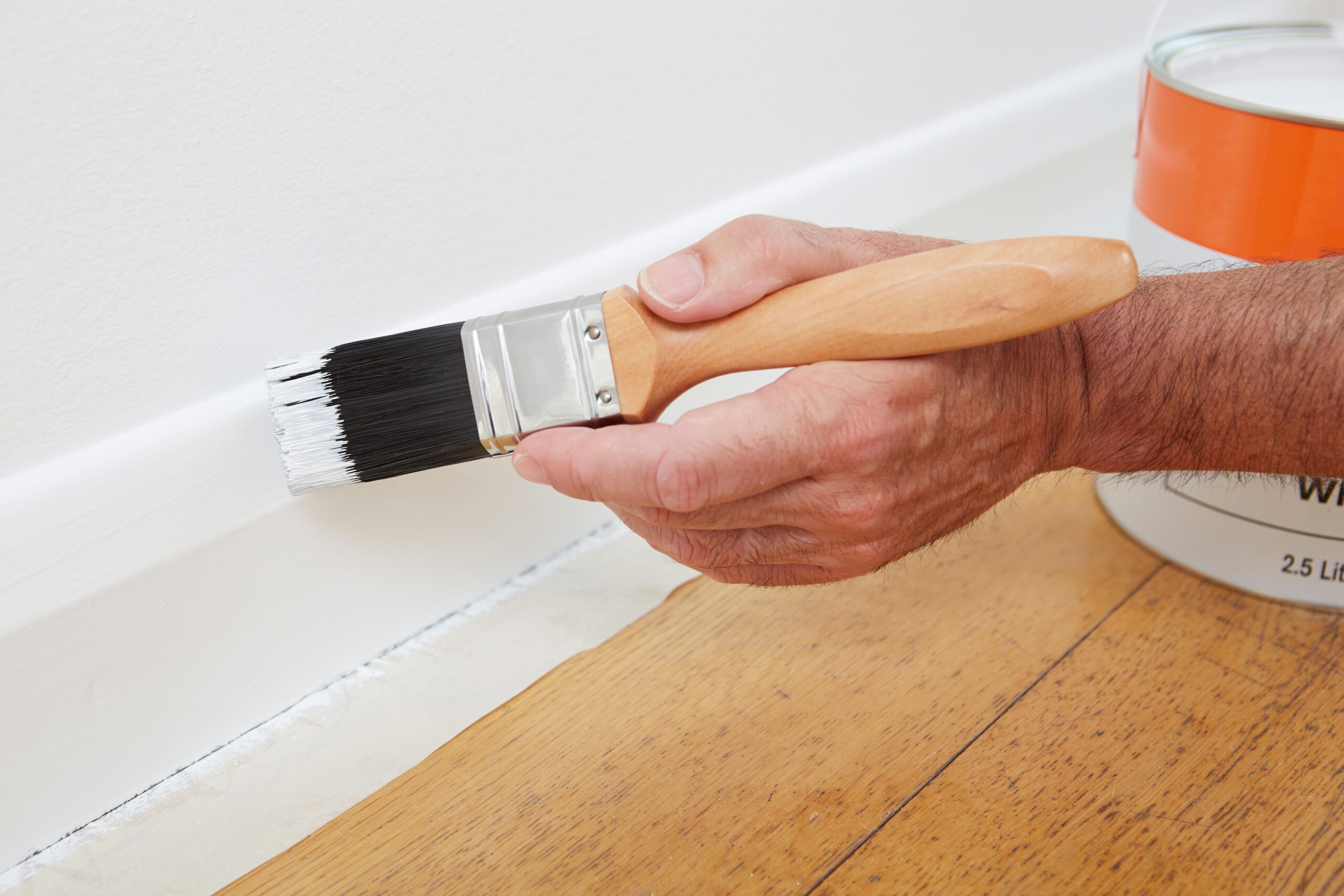 Close Up Of Man Painting Skirting Board