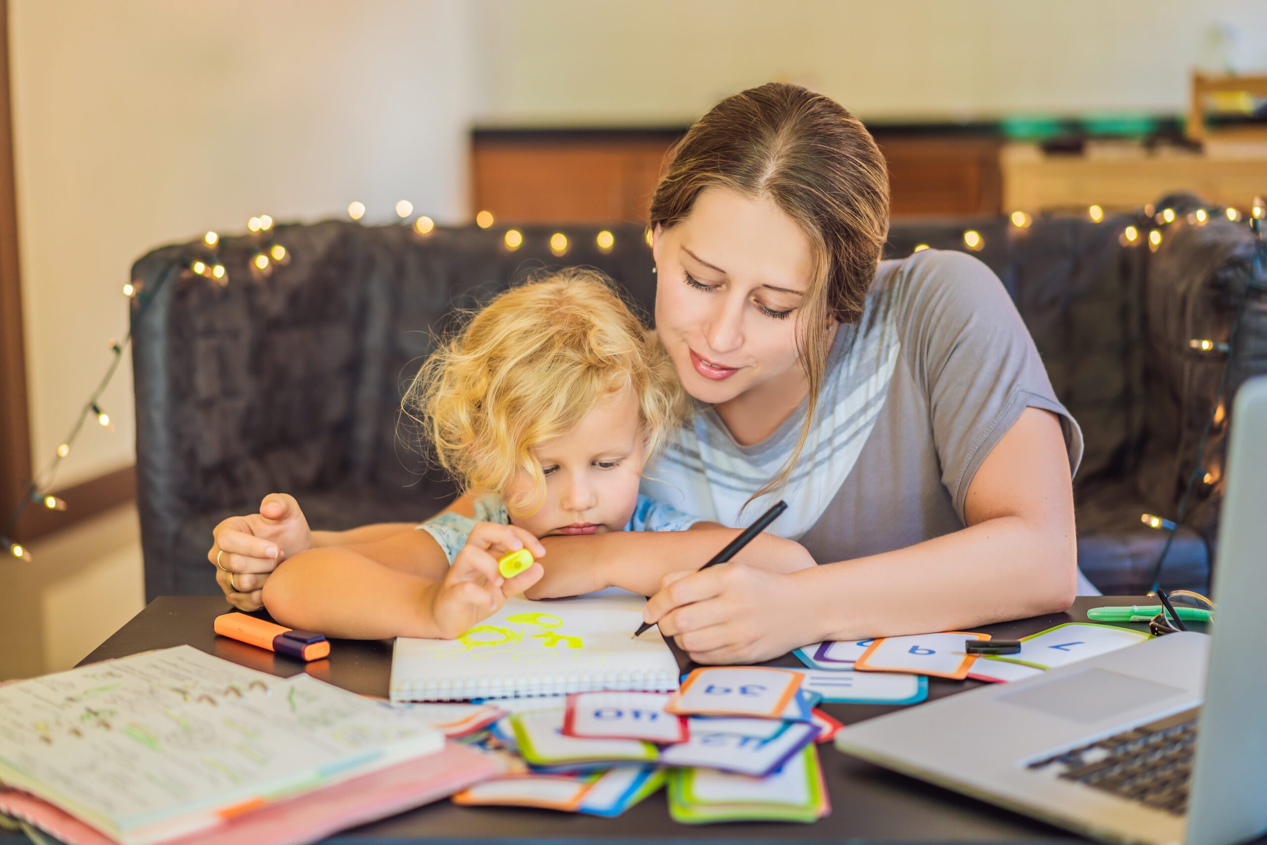 A teacher, a tutor for home schooling and a teacher at the table. Or mom and daughter. Homeschooling